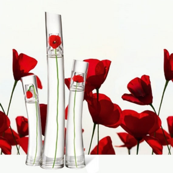 Trois flacons en verre à fleurs rouges par Kenzo.