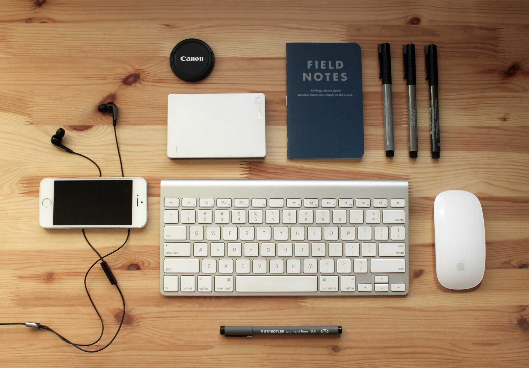 Un bureau avec un clavier, une souris, un téléphone portable et d'autres objets.