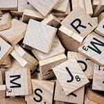 Une pile de tuiles de scrabble en bois affichant des lettres pour Référencement.