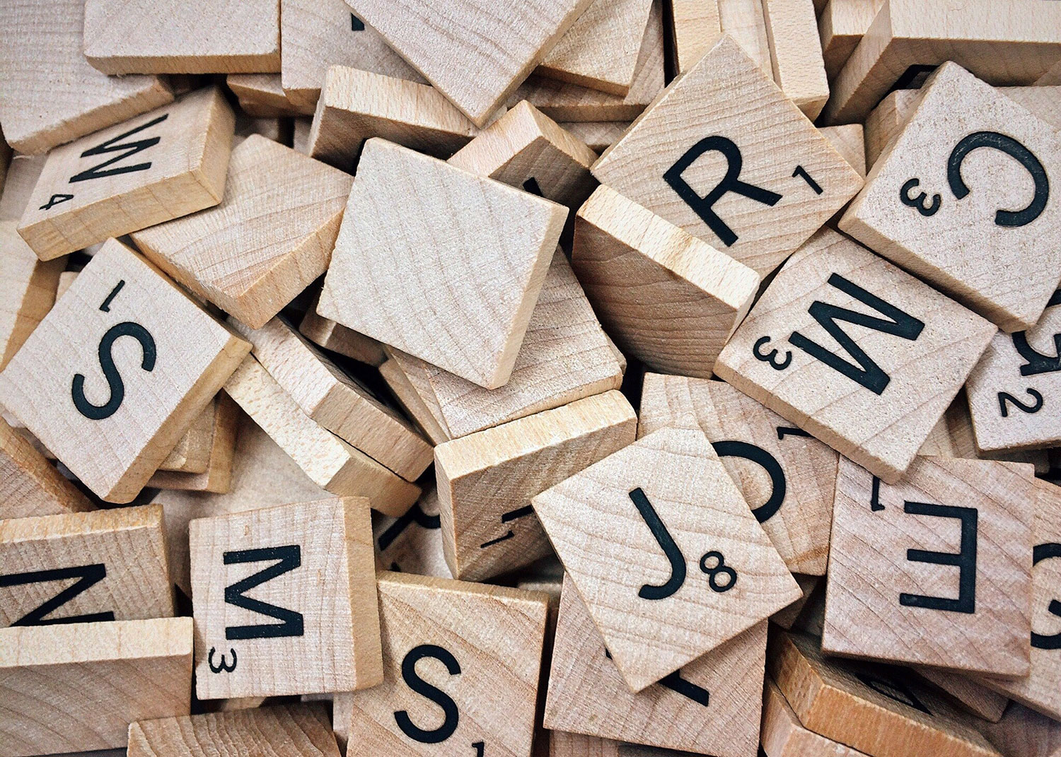 Une pile de tuiles de scrabble en bois affichant des lettres pour Référencement.