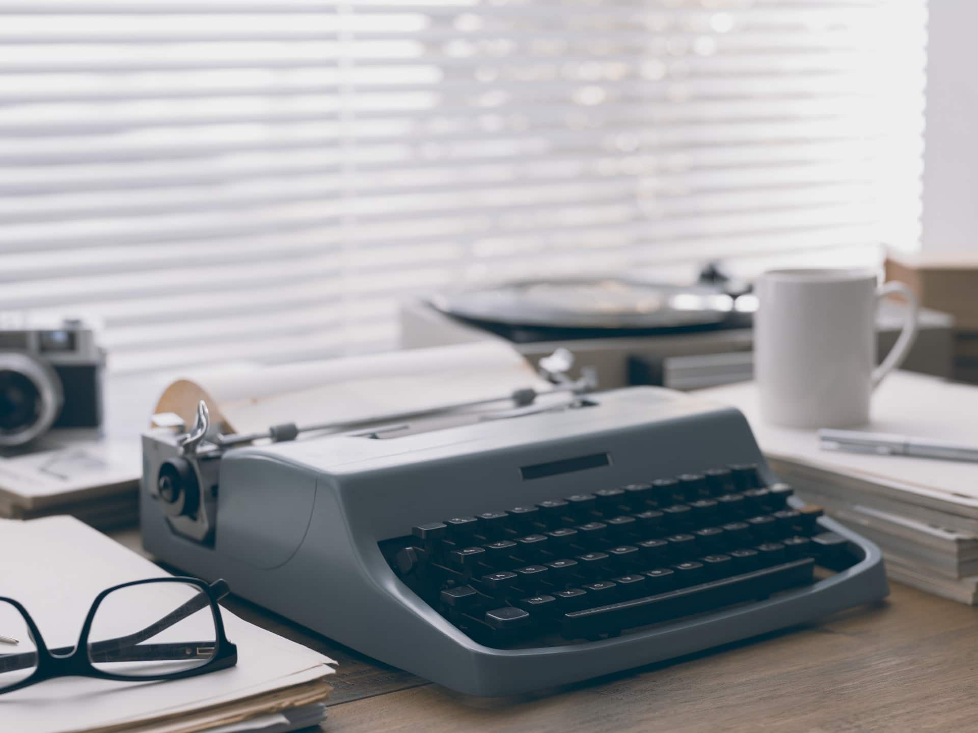 Une machine à écrire et une tasse de café occupent un bureau.