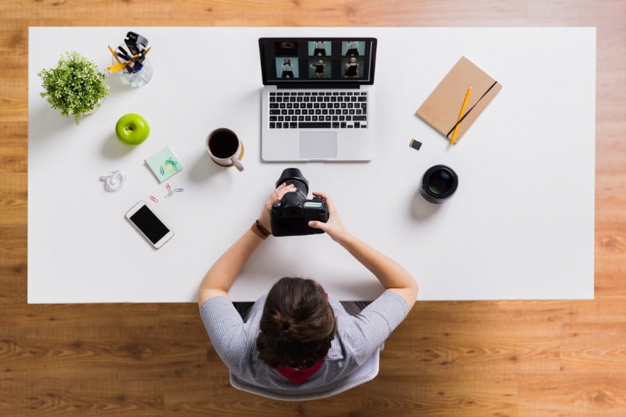 Une femme utilisant Imagify pour optimiser les images sur son site WordPress tout en travaillant sur un ordinateur portable à une table.