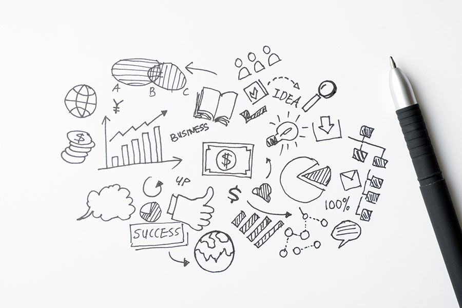 Un doodle d'icônes commerciales sur une feuille de papier illustrant l'infographie et les outils.