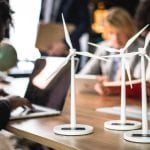 Un groupe de personnes assises autour d'une table empreinte avec des éoliennes.