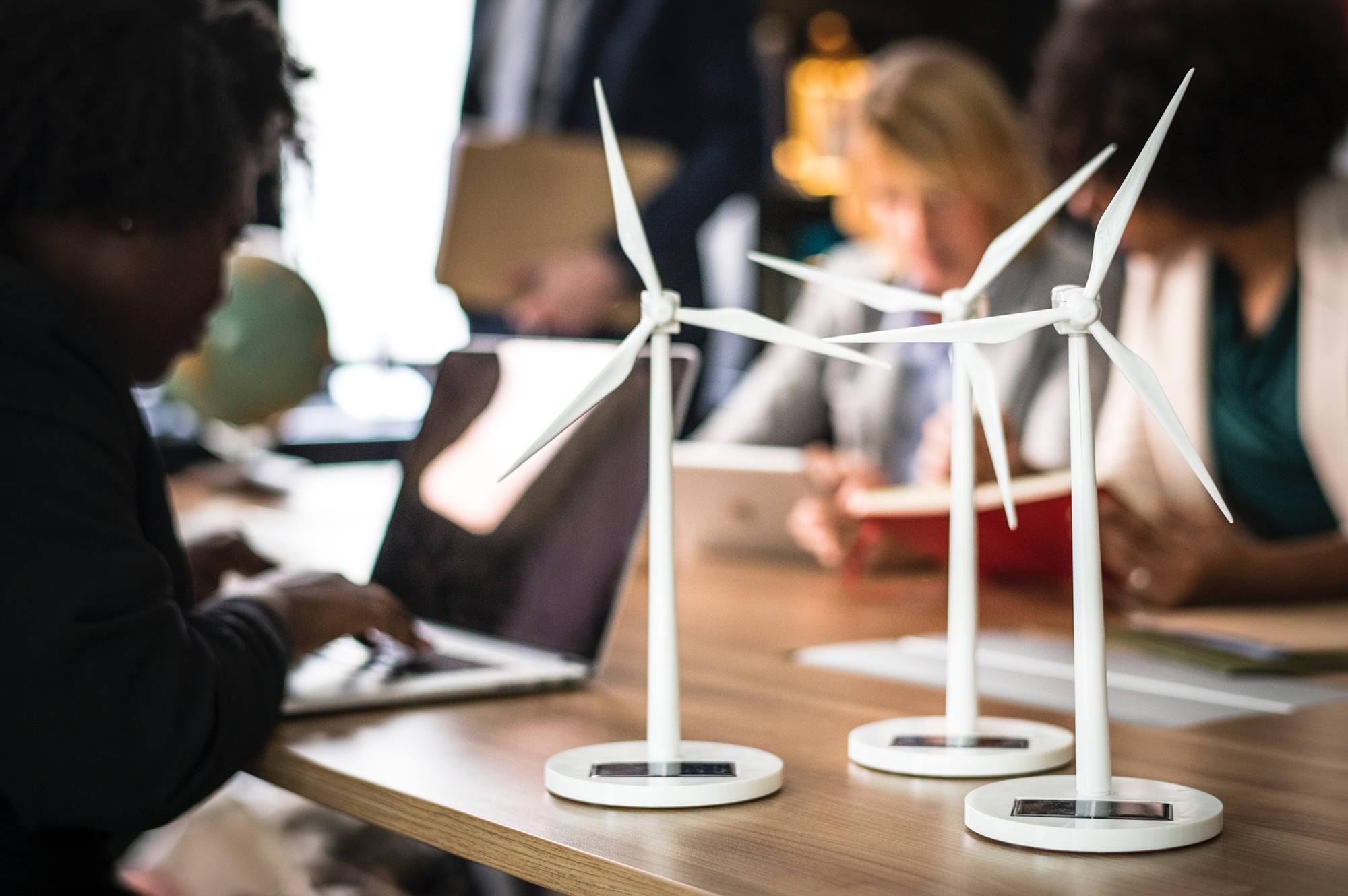 Un groupe de personnes assises autour d'une table empreinte avec des éoliennes.