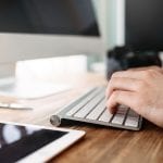 Un homme tape sur un clavier pour formater des images dans WordPress à l'aide de webp.