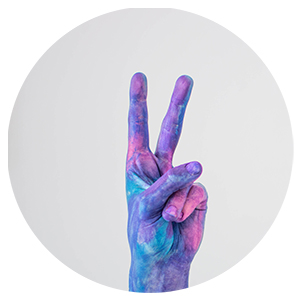 Une main peinte en bleu et violet avec un signe de paix.