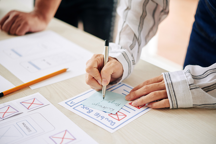 Une personne créant un croquis de conception UX sur papier.