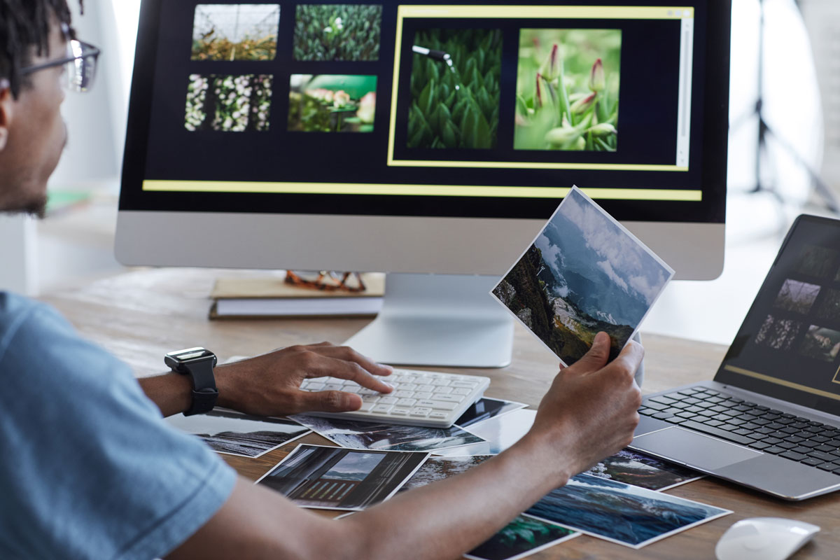 Un homme explorant le logiciel de visualisation de photos Enhance.io sur un écran d'ordinateur.