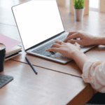 Une femme tapant sur un ordinateur portable à un bureau tout en utilisant Convertio.co.