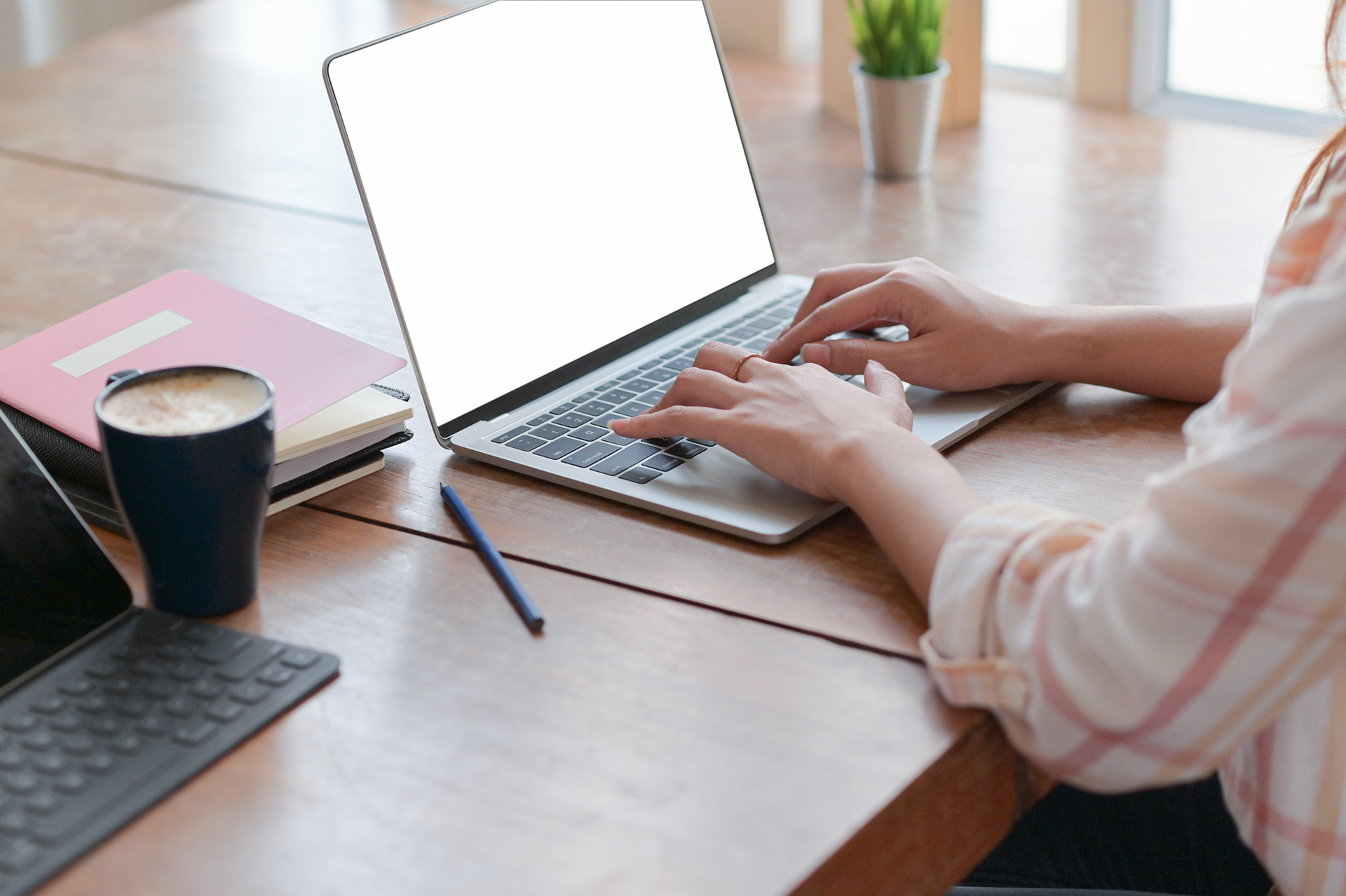 Une femme tapant sur un ordinateur portable à un bureau tout en utilisant Convertio.co.