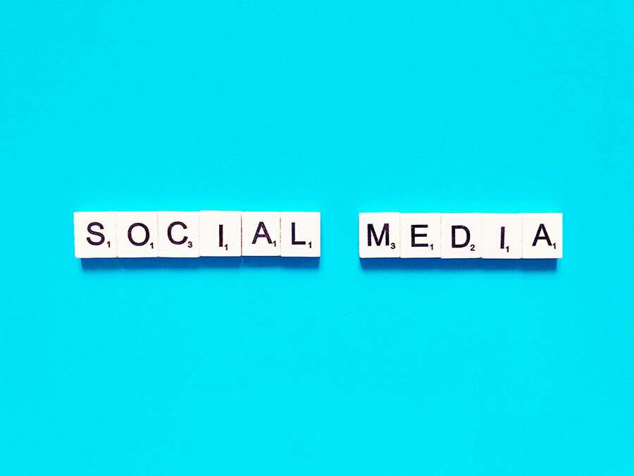 Un fond bleu affiche le mot "médias sociaux" de manière accrocheuse.