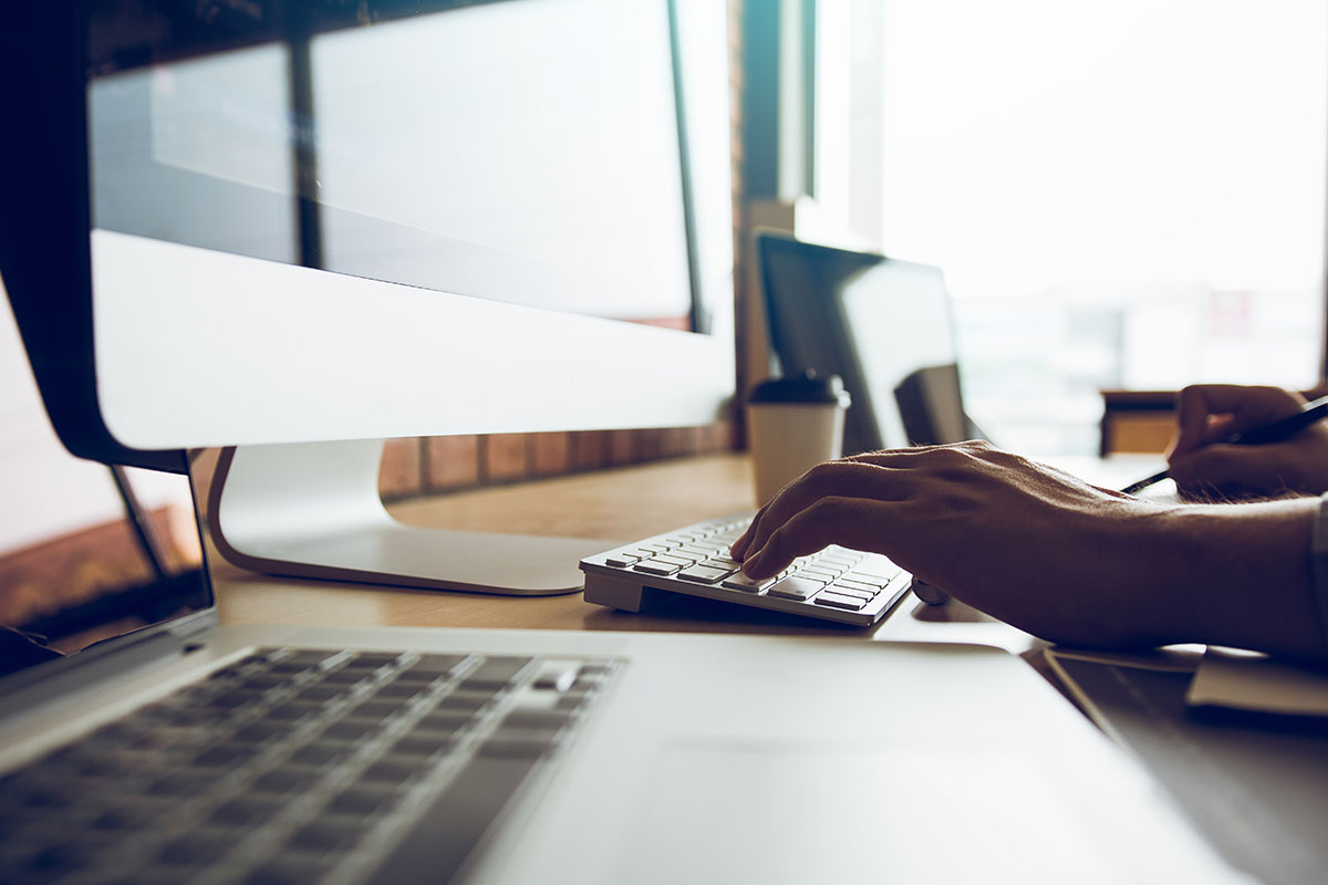 Une personne optimisant l'accessibilité du Web en tapant sur un ordinateur à un bureau.